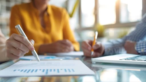 A woman in a yellow shirt sits behind a desk and reviews a property tax loan document